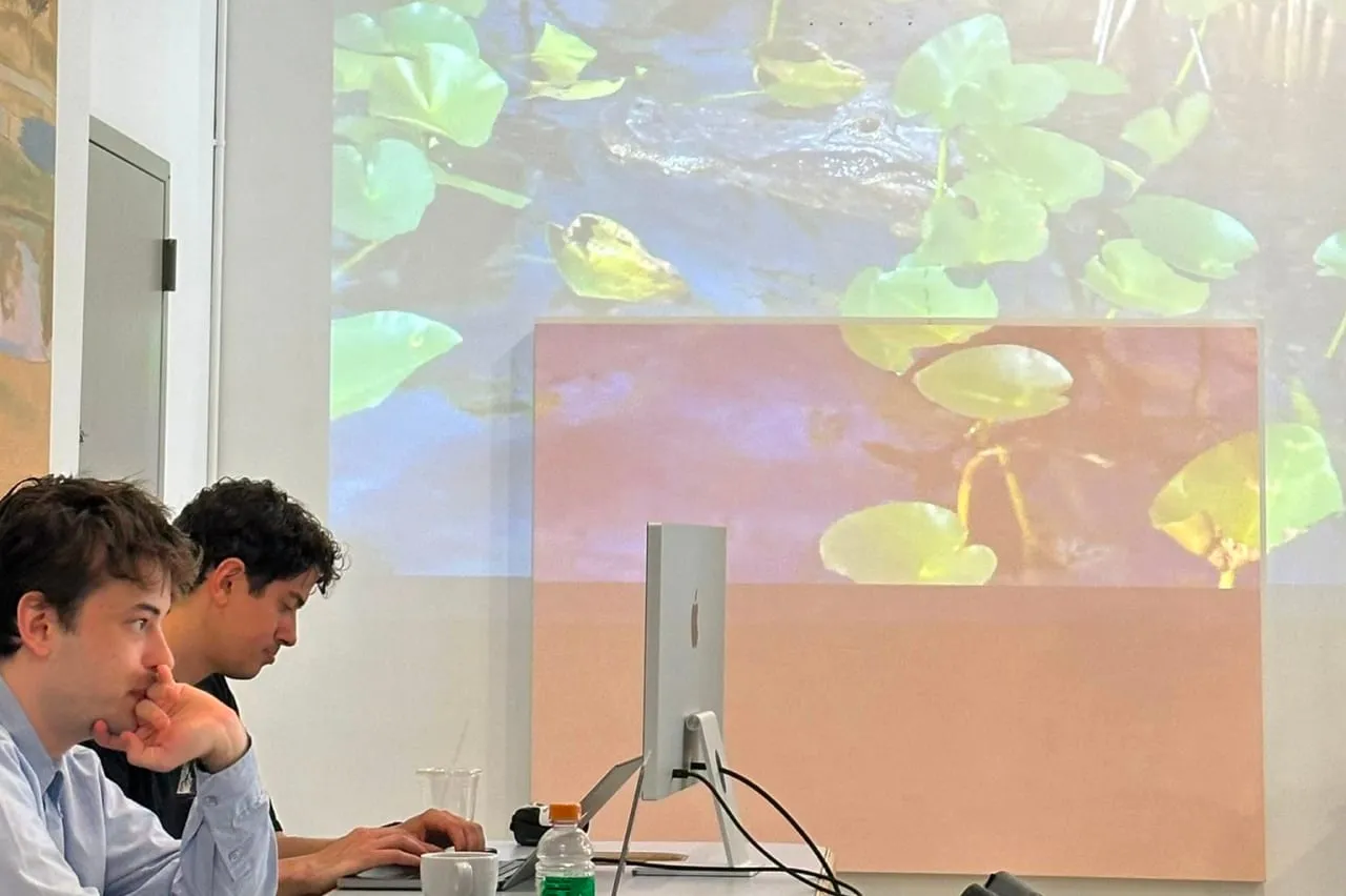 Two attendees working beneath a colorful projection.
