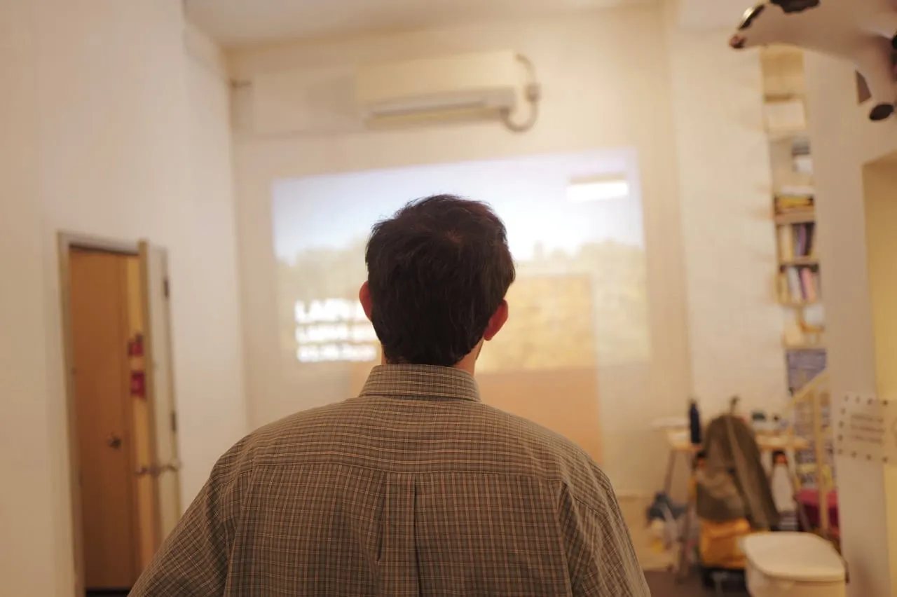 An attendee watching a presentation projected on the wall.
