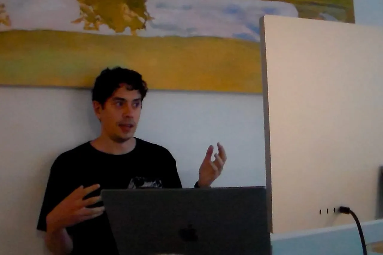 A participant explaining a project from behind a laptop.